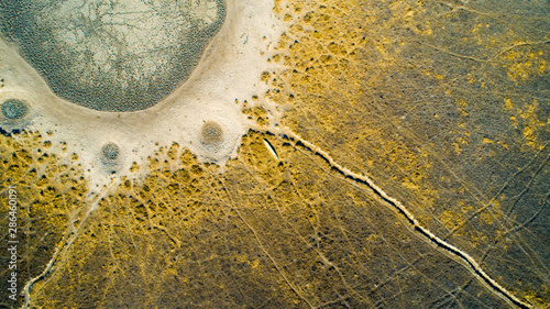 Aerial view of a small canoe next to a dried-up waterhole in Africa, Botswana, Okavango Delta in the dry season