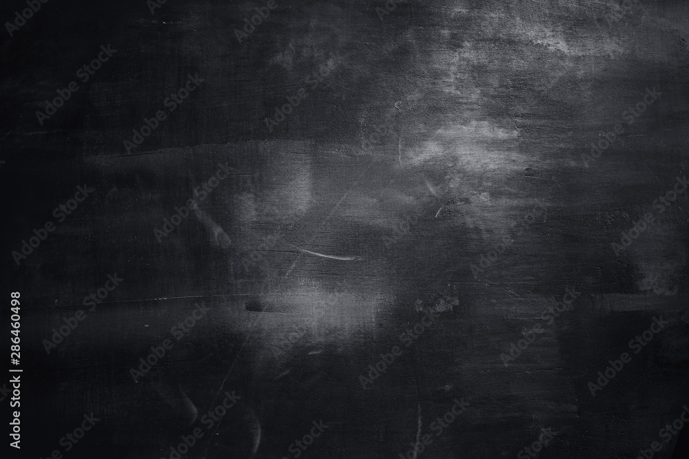 Obraz premium Abstract decorative textured dark black background with beautiful gray spots, strokes and stains. Texture of wall with decorative plaster on plywood, copy space.