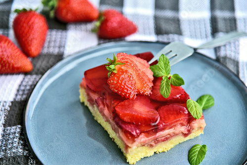Classic traditional German Strawberry Cake on blue dish with mint leaf and fresh strawberry.
