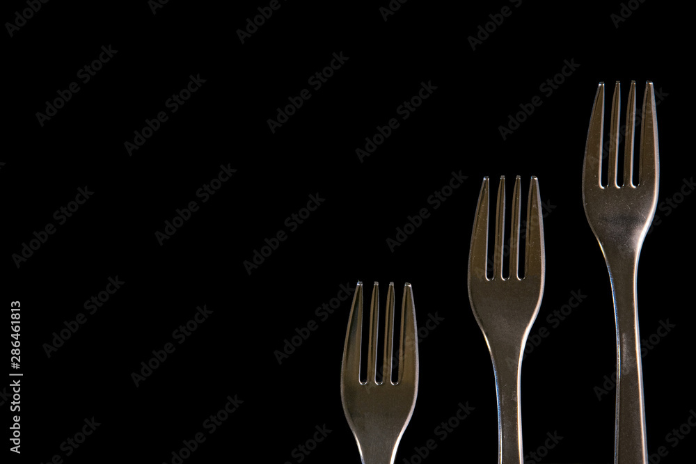 metal forks on a black background. top view on stainless forks with copy space