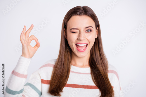 Closeup photo of nice lady showing okey symbol winking eye wear striped fluffy pullover isolated white background
