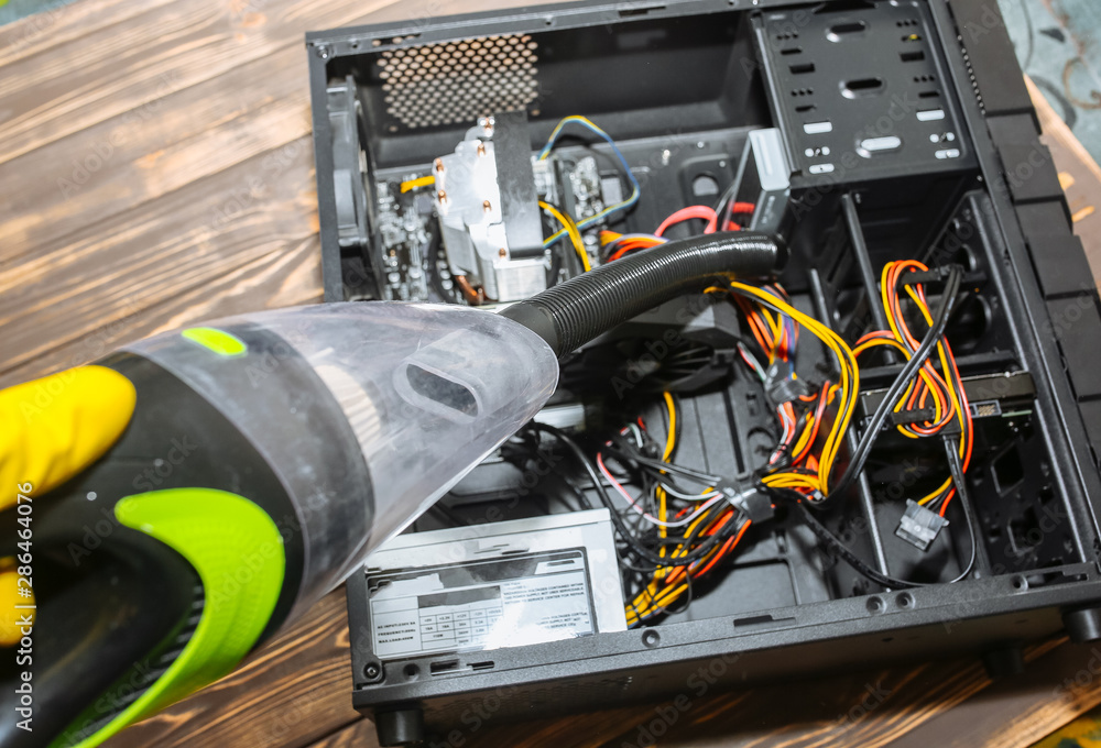 Inside details of the personal computer. Man is cleaning wires with vacuum  cleaner. Small hoover. Motherboard and video card in the dust. Broken PC.  Stock Photo | Adobe Stock