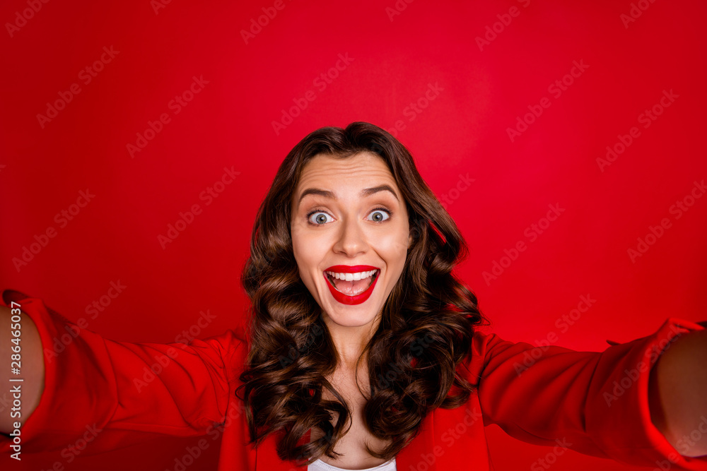 Close up photo of cheerful lady with long hairstyle making selfie isolated over red background Close up photo of cheerful lady with long hairstyle making selfie isolated over red background