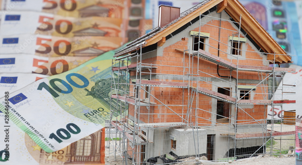 House under construction with Euro banknotes in background House under construction with Euro banknotes in background