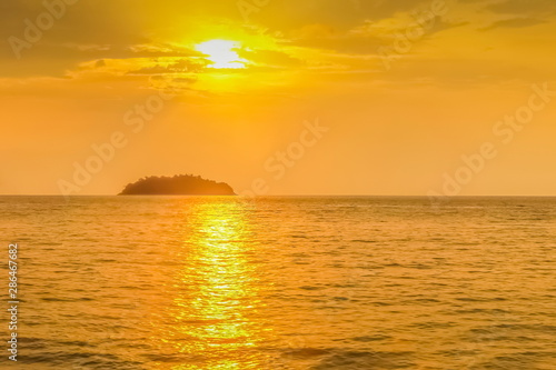 view seaside evening of a small island with yellow sun light background, sunset at Kai Bae Beach, Koh Chang Island, Trat Province, Thailand.