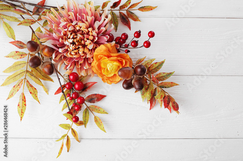 Fotografie autumn leaves and fruits on wooden background