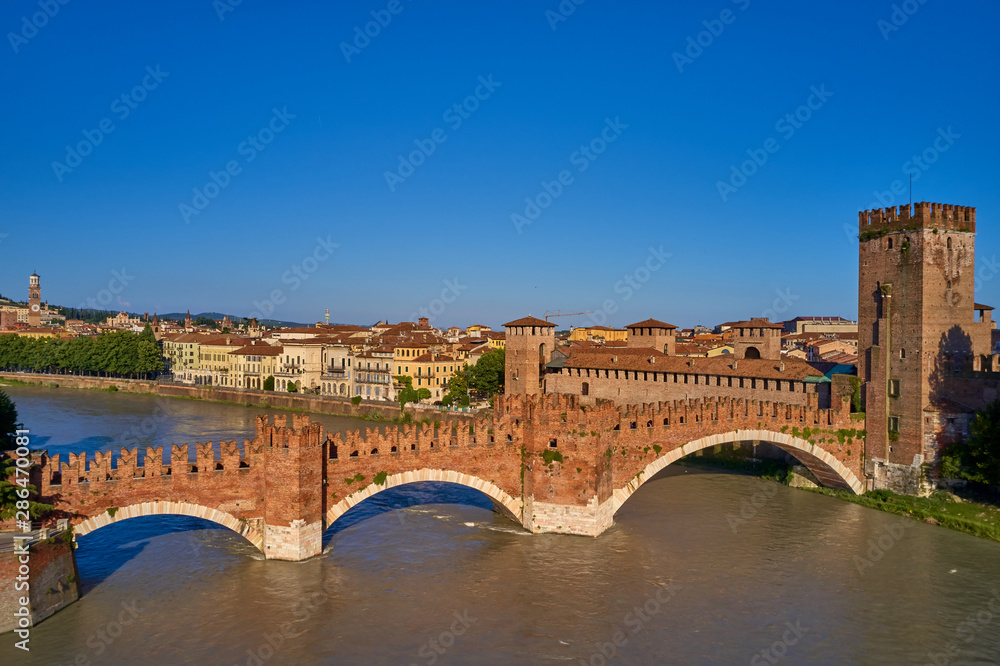 Adige river and fortified medieval castle of Castelvecchio. Aerial drone panoramic photo from  city of Verona. Verona, Italy.