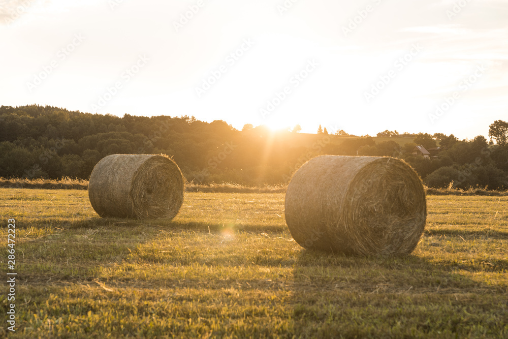 Beautiful landscape with rolls of hays and sunset