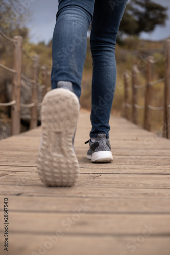 Runner feet running on wood bridge closeup on shoe. Selective focus