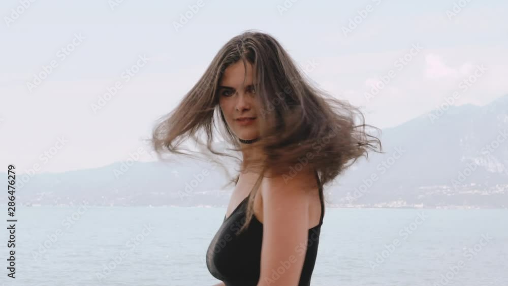 Beautiful girl looking in the camera lake garda and mountains sirmione veneto italy August 2019 Beautiful girl looking in the camera lake garda and mountains sirmione veneto italy August 2019