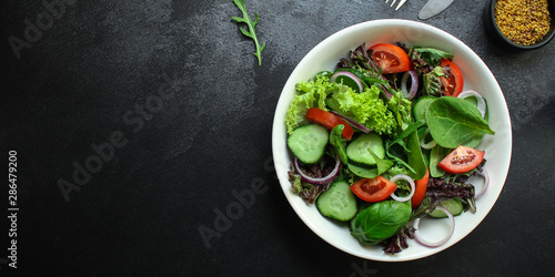 healthy salad (tomato, cucumber, mix leaves, onions and other ingredients) top menu concept. food background. copy space