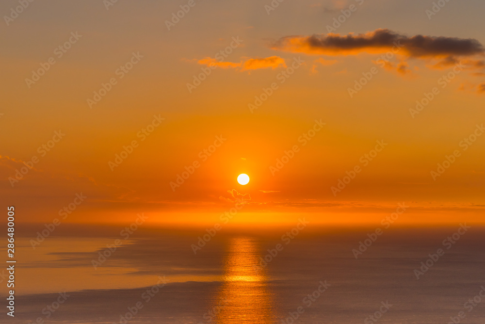 Orange sunset reflecting over the calm ocean