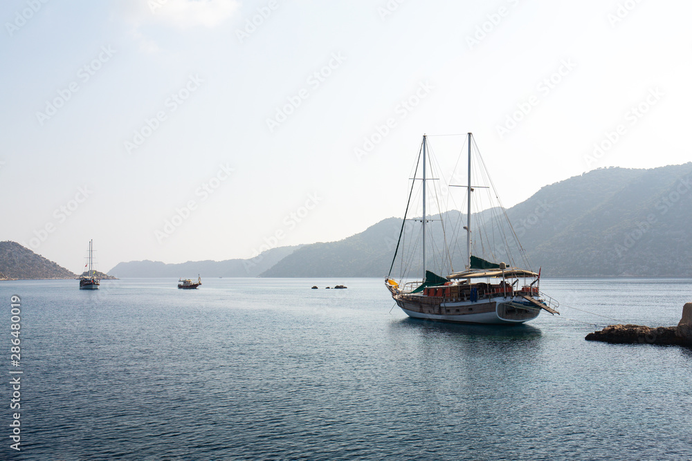 Fototapeta premium Powerboat. View from the boat. Mediterranean sea overlooking the mountains. Aerial top view of sea waves hitting rocks on the beach with turquoise sea water.