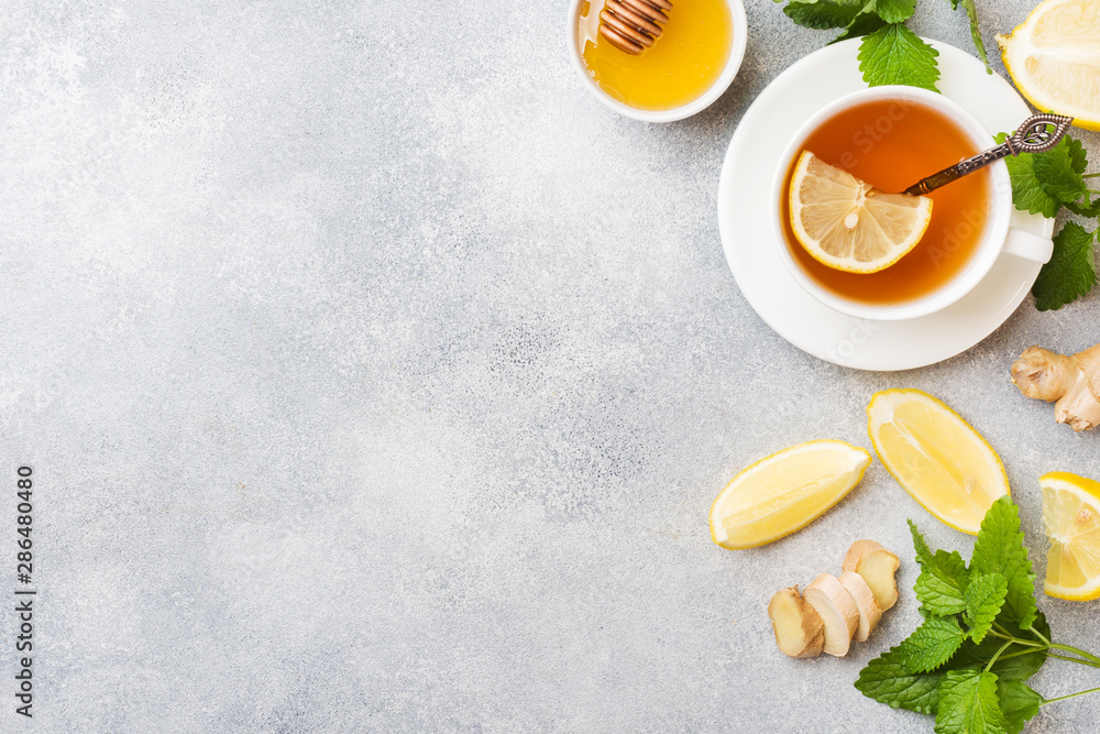 White Cup with natural herbal tea ginger lemon mint and honey. Gray background Copy space. White Cup with natural herbal tea ginger lemon mint and honey. Gray background Copy space.