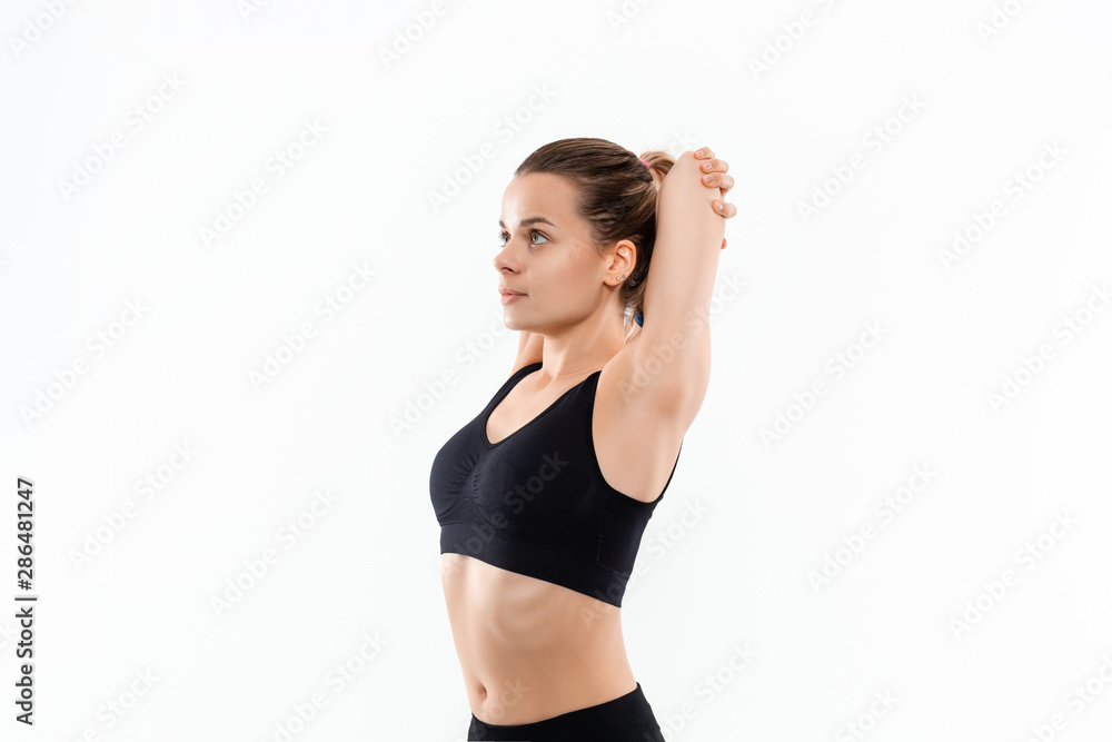 Young sporty blond woman in a black sportswear stretching before exercising isolated over white background. Young sporty blond woman in a black sportswear stretching before exercising isolated over white background.