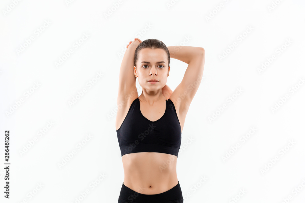 Young sporty blond woman in a black sportswear stretching before exercising isolated over white background. Young sporty blond woman in a black sportswear stretching before exercising isolated over white background.
