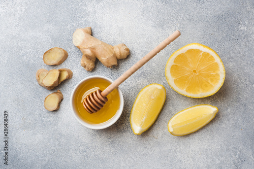 Lemon honey and ginger root on grey background with copy space. Ingredients for a tonic vitamin drink.