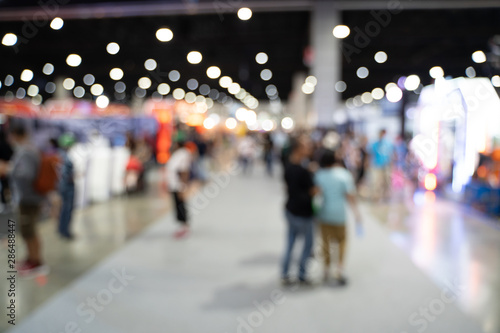 Blurred images of trade fairs in the big hall. image of people walking on a trade fair exhibition or expo where business people show innovation activity and present product in a big hall.