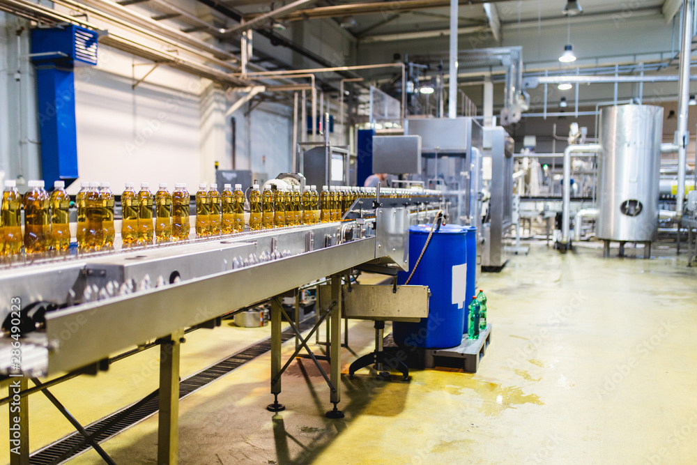 Bottling factory - Apple juice bottling line for processing and bottling juice into bottles. Selective focus.