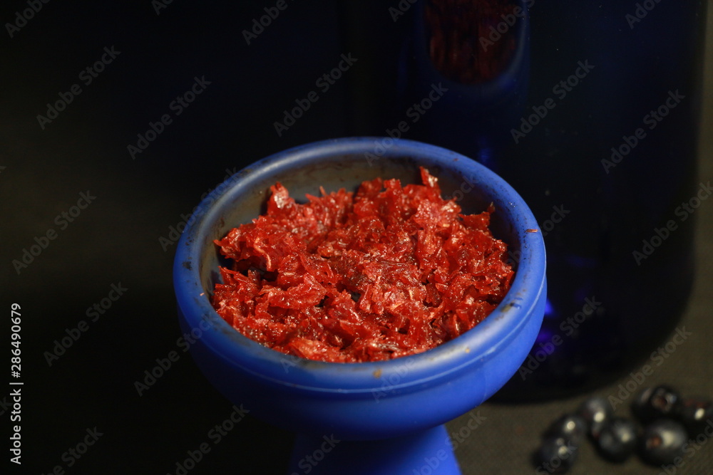 bowl with tobacco for hookah. fruits on a black background bowl with tobacco for hookah. fruits on a black background