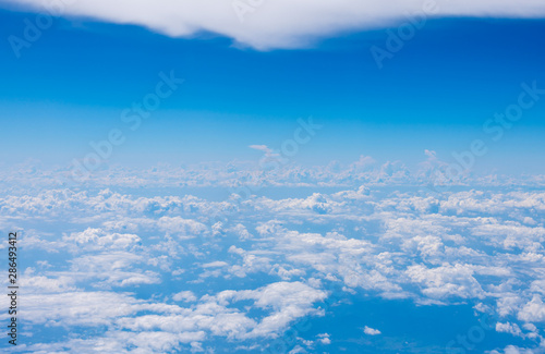 The blue sky and white clouds at an altitude of 10,000 meters under the sun