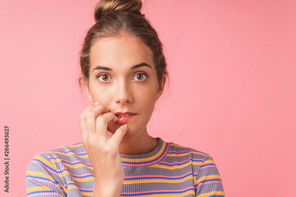 Image closeup of surprised beautiful woman expressing wonder and biting her nails Image closeup of surprised beautiful woman expressing wonder and biting her nails