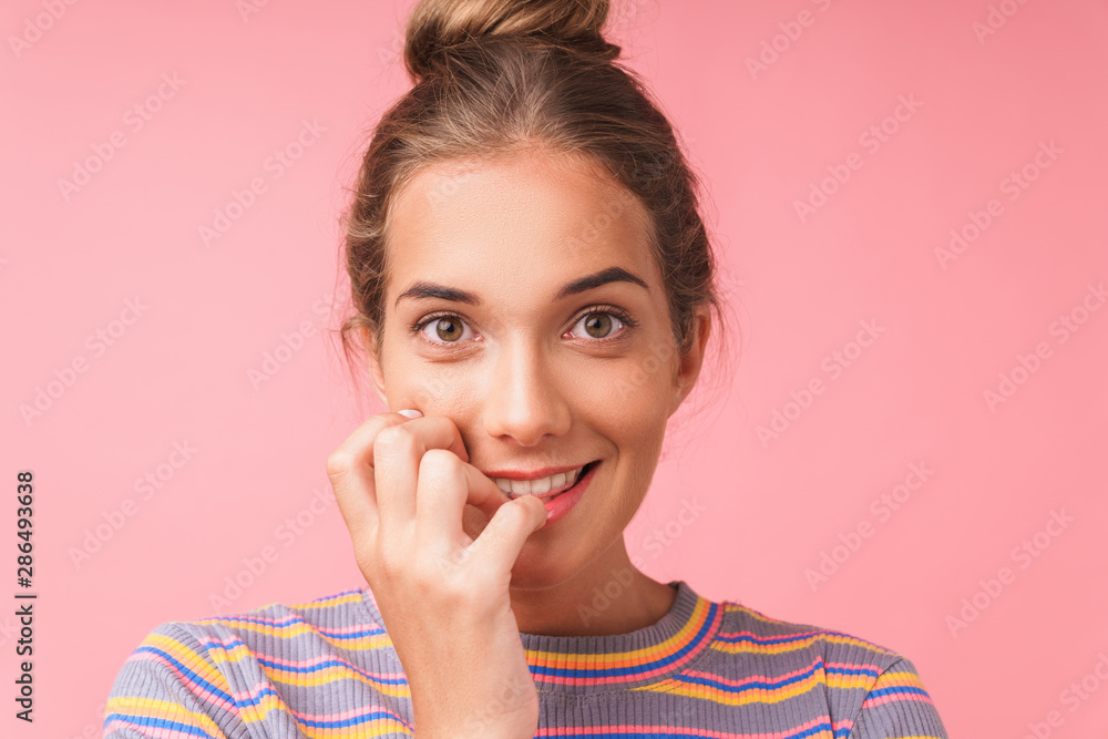 Image closeup of adorable beautiful woman wearing casual clothes smiling and biting her nails Image closeup of adorable beautiful woman wearing casual clothes smiling and biting her nails