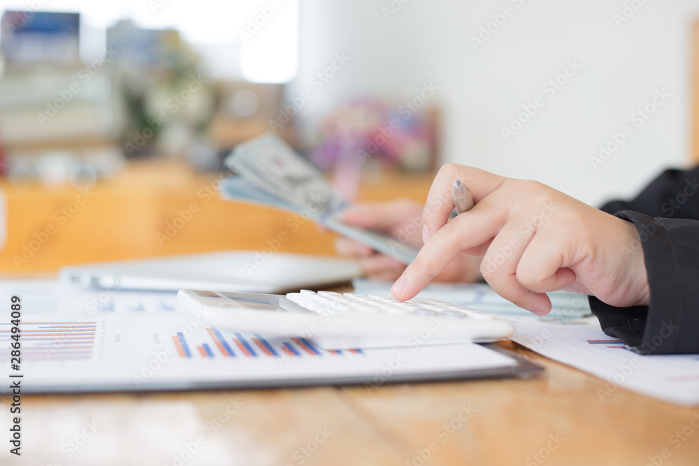 Data analysis, Financial accountants are evaluating company revenue data using calculators and databases to compute and summarize for leaders, Young women working. Data analysis, Financial accountants are evaluating company revenue data using calculators and databases to compute and summarize for leaders, Young women working.
