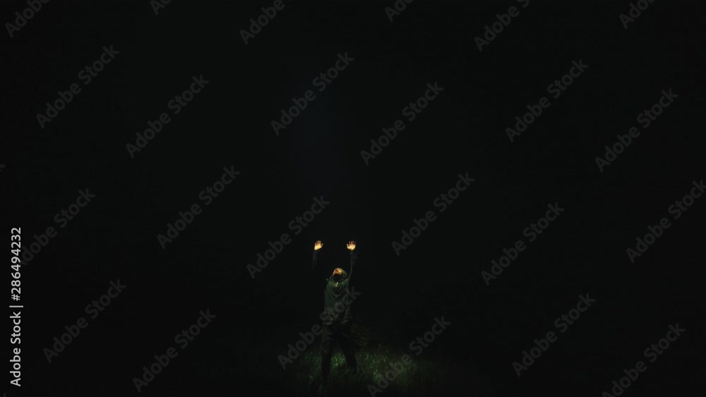The bright light from a sky shines on a man in the dark The bright light from a sky shines on a man in the dark