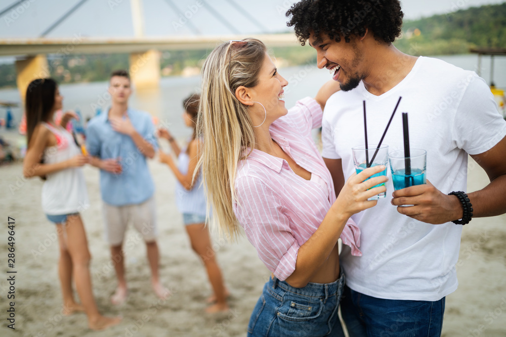 Smiling happy couple having fun on the beach. Holidays, vacation, love and friendship concept Smiling happy couple having fun on the beach. Holidays, vacation, love and friendship concept