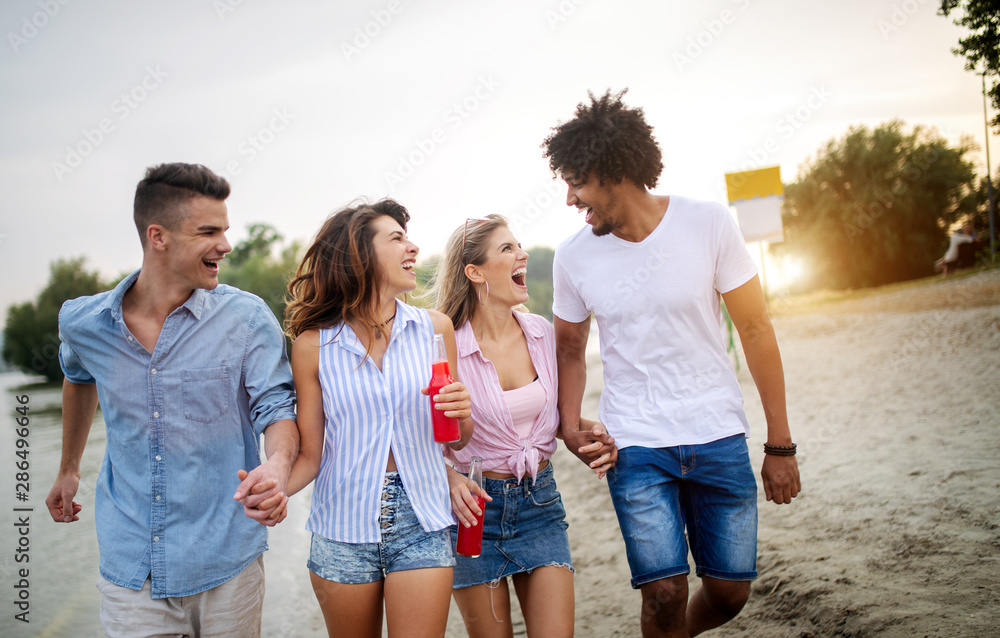 Group of friends having fun on the beach. Summer holidays, vacation and people concept.