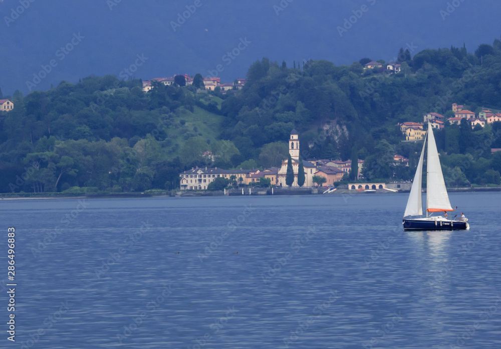 Fototapeta premium Lombardy - Italy. Evening on the Como lake furrowed by a sailboat