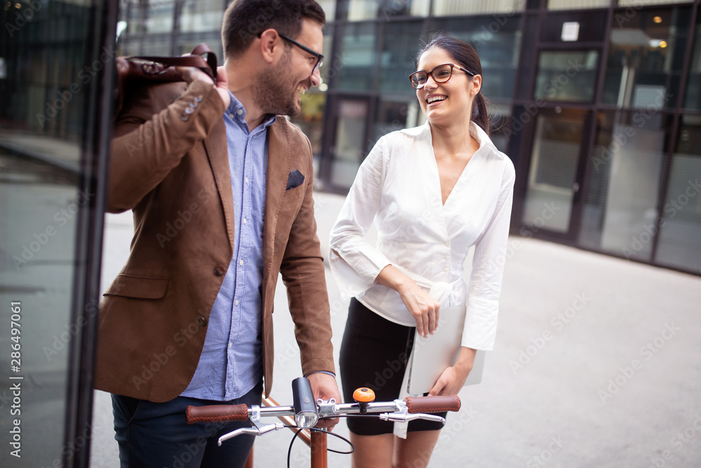 Obraz premium Business people discussing and smiling while walking together outdoor