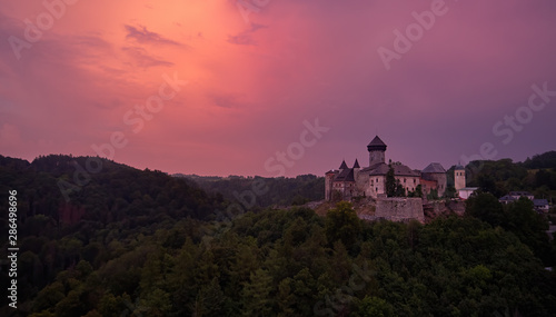 Aerial view on  Castle Sovinec  Eulenburg  robust medieval fortress  one of the largest in Moravia  Czech republic. Czech landscape with medieval castle on a rocky hill against dramatic  orange sky.