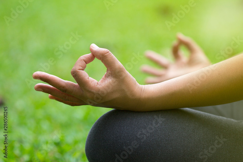 Woman do yoga outdoor, Yoga in the park, Close up hands, Concept of healthy lifestyle and relaxation. © Somprasong