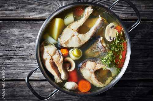 spicy Trout fish soup in a metal pot photo