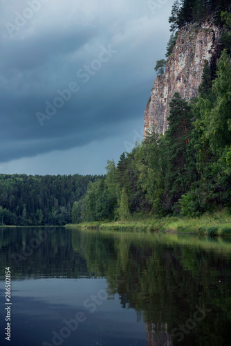 Fototapeta Naklejka Na Ścianę i Meble -  The river against the backdrop of mountains and forests in cloudy weather.