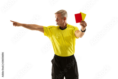 Referee showing a red and yellow cards to a football or soccer player while gaming on white studio background. Concept of sport, rules violation, controversial issues, obstacles overcoming.