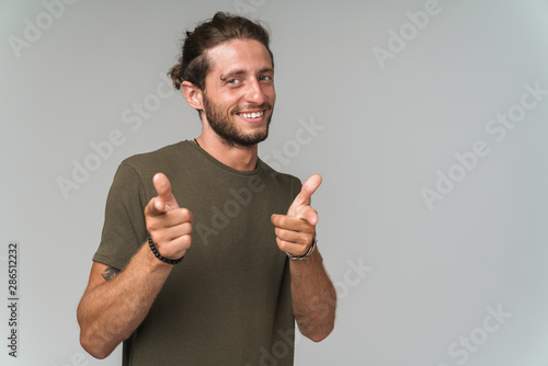 Smiling young casual man standing isolated
