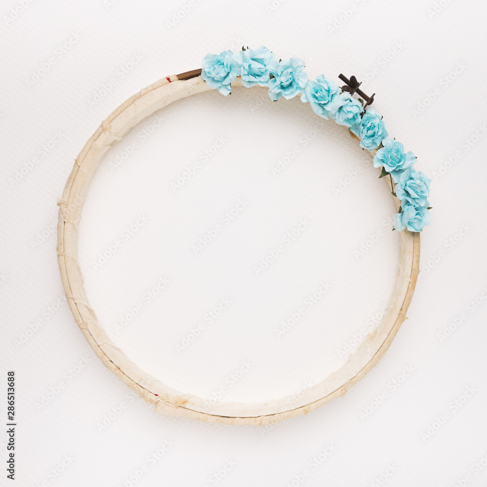 Blue roses on the wooden circular border frame on white backdrop Blue roses on the wooden circular border frame on white backdrop