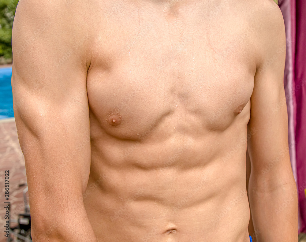 Naked male torso close-up after swimming in the pool