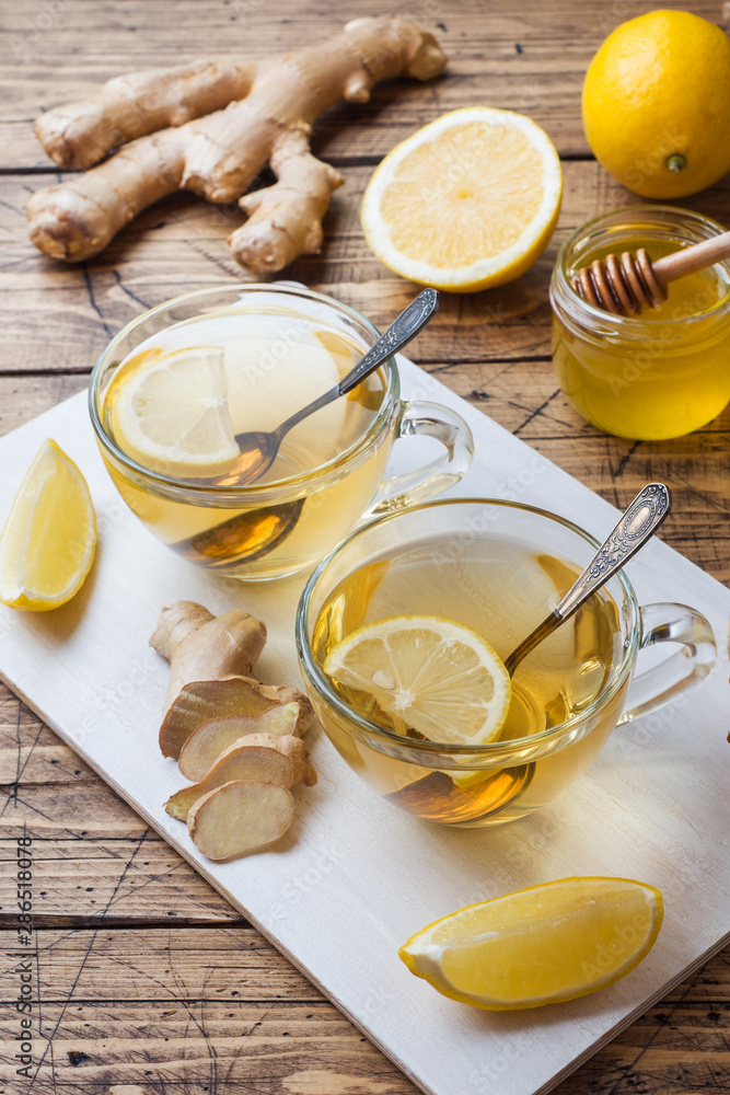 Two cups of natural herbal tea ginger lemon and honey on a wooden background. Two cups of natural herbal tea ginger lemon and honey on a wooden background.