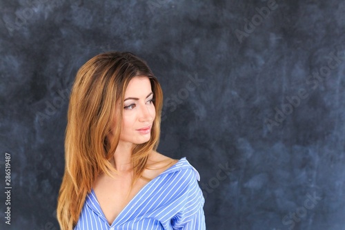 Beautiful girl in a blue striped shirt black background. © Катерина Рябцева