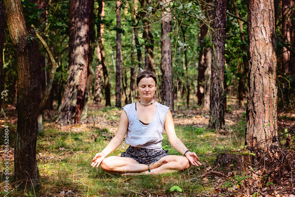 young woman meditating alone and silent in summer forest young woman meditating alone and silent in summer forest