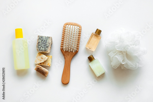 Flat lay bath products  cosmetic for shower. Shampoo or shower gel  soap bar  cotton towel  wooden comb and seashells. Top view photo natural cosmetics