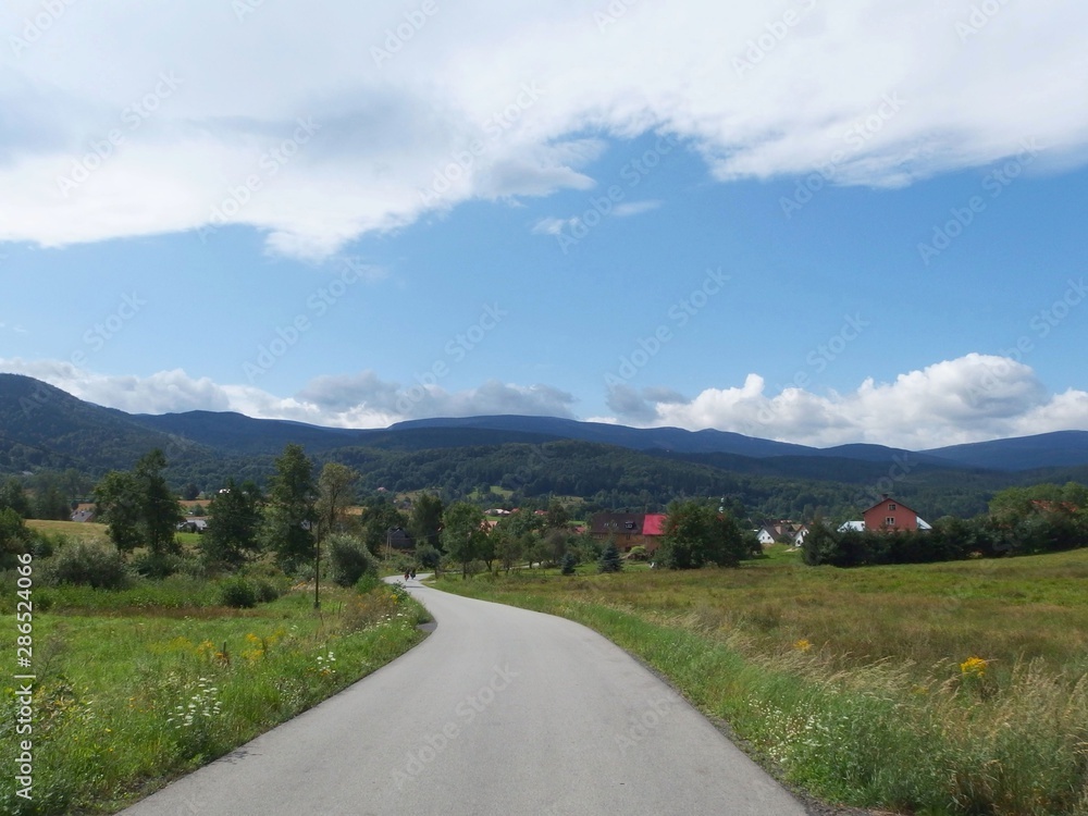 A picturesque road with a view of the mountains near Sosnówka. Karkonosze, Poland