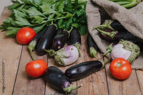 Tomatoes, eggplant and sack on wooden boards photo