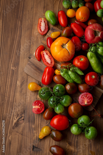 Fresh ripe and green tomatoes on wood