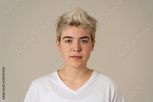 Natural portrait of young handsome transgender boy posing with neutral face expression