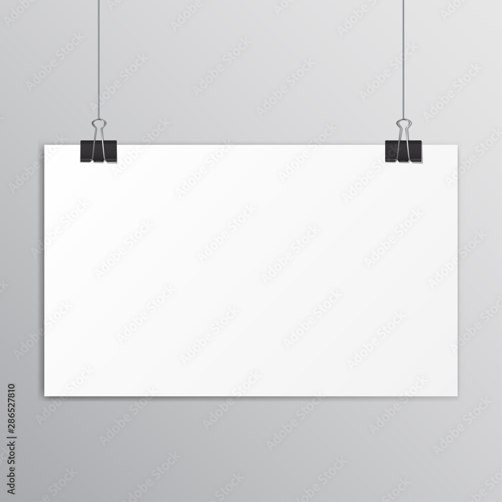 White paper hanging on a black paper clip with shadow on grey background. White paper hanging on a black paper clip with shadow on grey background.